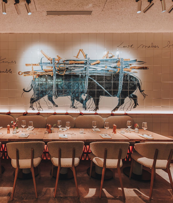 Lange eettafel bij Lucy’s Table met kunstwerk en symmetrische tafelopstelling